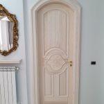 Porta in abete sbiancato con bugne e rosone in rilievo
