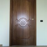 Porta in frassino con bugne e rosone